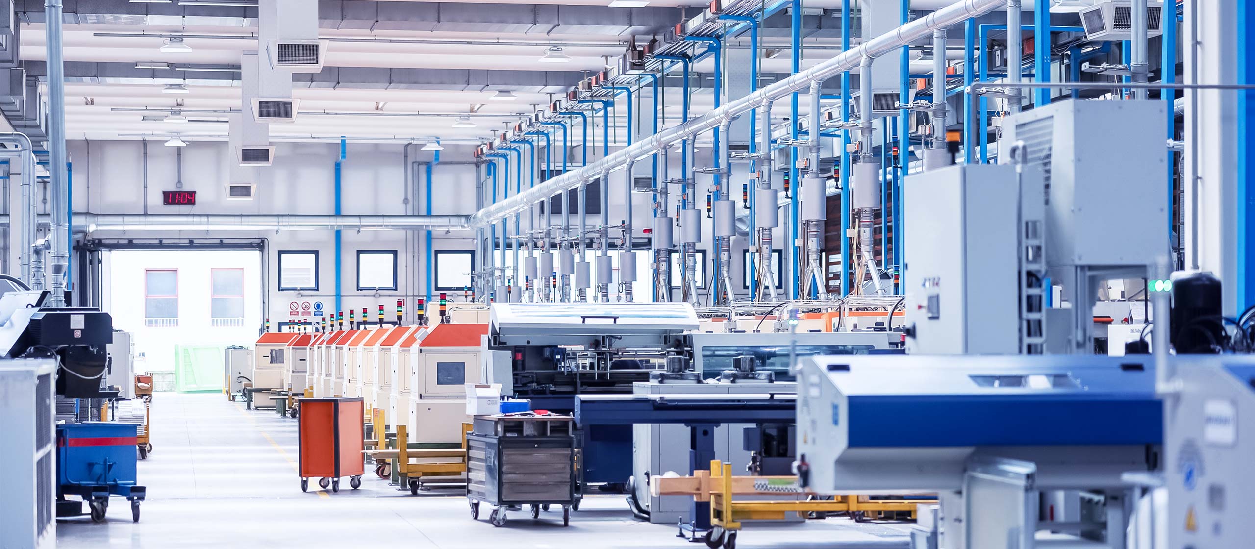 Interno di una fabbrica con diverse macchine e attrezzature in attività.